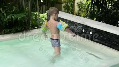 穿着袖子和帽子的小男孩在度假时跳进<strong>游泳</strong>池。 男孩在热带的<strong>游泳</strong>池里<strong>游泳</strong>。 <strong>儿童</strong>潜水